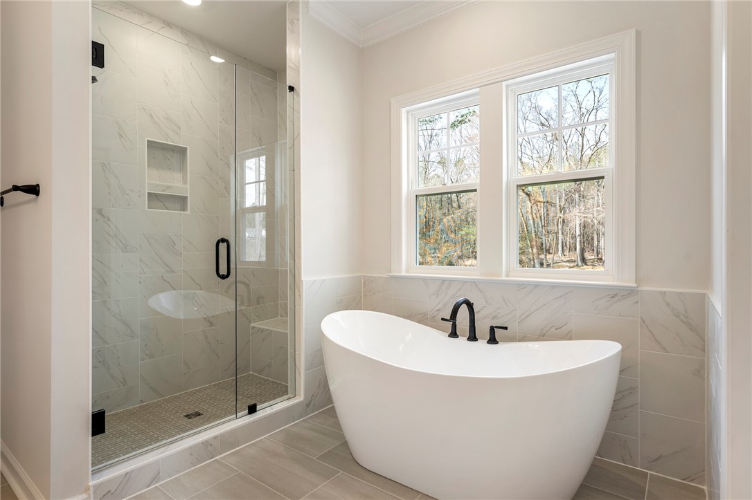 114 Lakeside Drive Anderson, SC 29621 - Photo 22 of 37 This serene bathroom offers a luxurious soaking tub and a spacious walk-in shower with natural light.