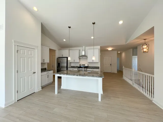 a view of kitchen with center island wooden floor and appliances