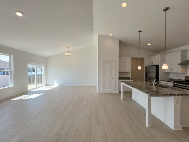 a large kitchen with kitchen island a large counter space a sink appliances and a window