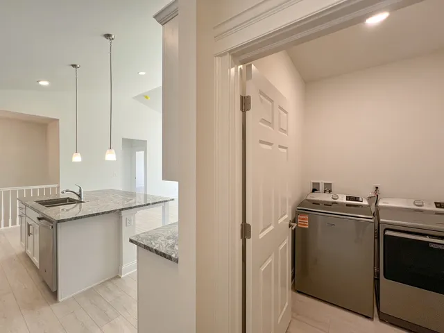 a kitchen with stainless steel appliances granite countertop a sink and a refrigerator