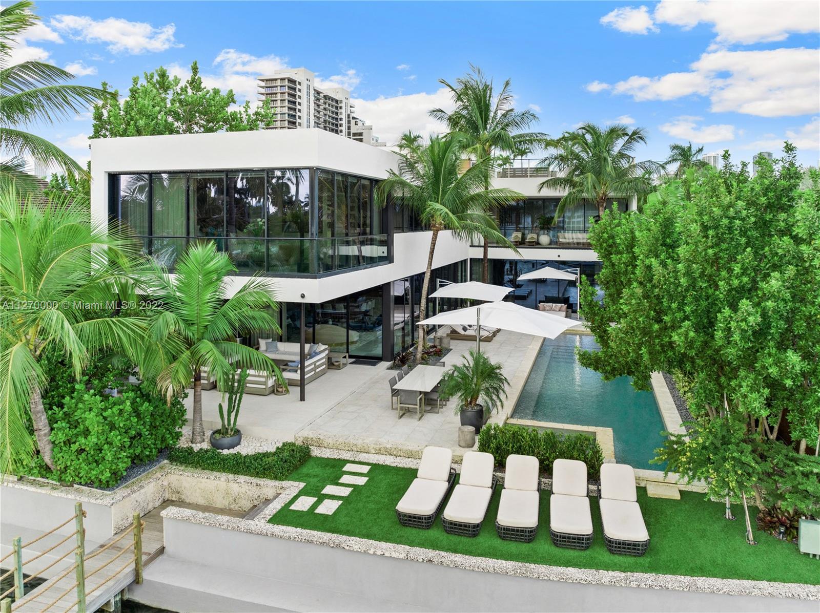 1142 North Venetian Drive Miami Beach, FL 33139 - Photo 1 of 47 a view of a patio with table and chairs potted plants and a palm tree