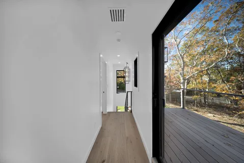 a view of a hallway with closet and window