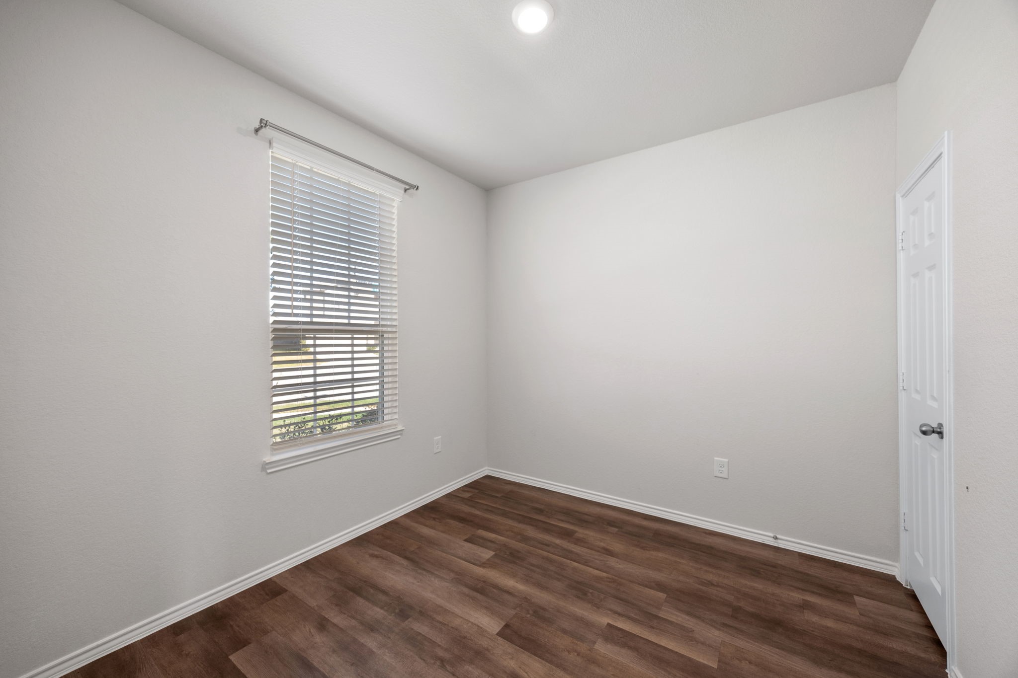 25411 Farmstead Prairie Place Katy, TX 77493 - Photo 14 of 30 a view of an empty room with wooden floor and a window