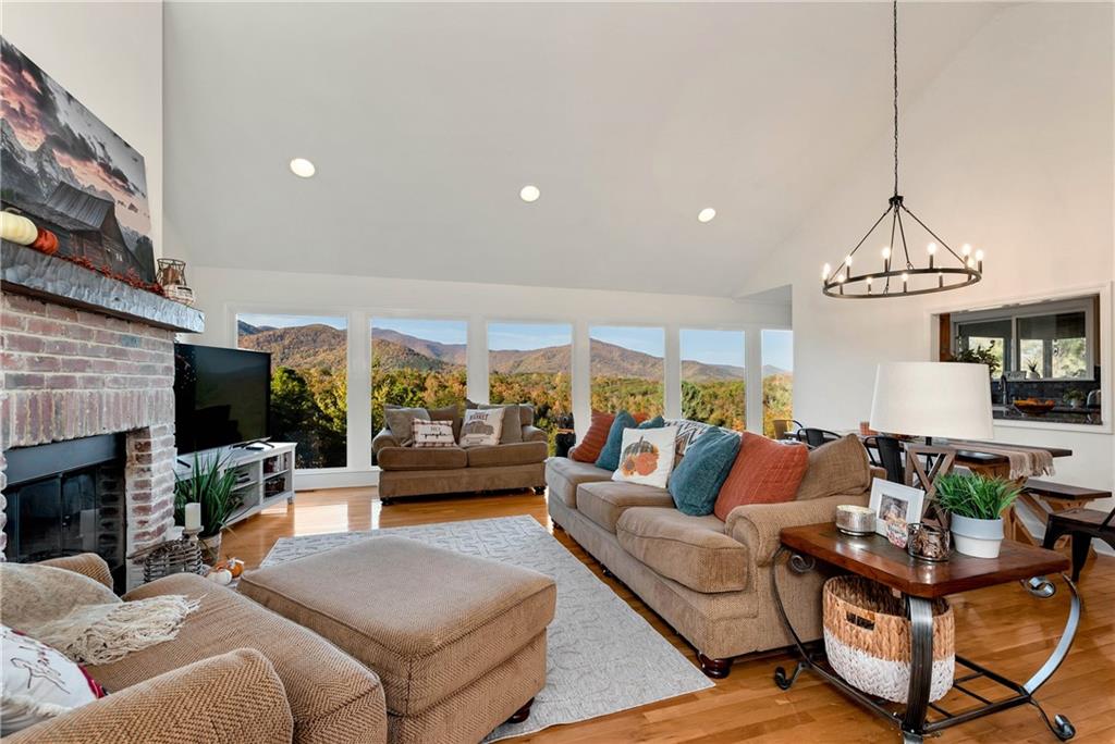 962 Woodbrier Sautee Nacoochee, GA 30571 - Photo 13 of 52 a living room with furniture a chandelier and a fireplace