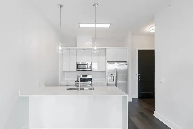 a kitchen with kitchen island white cabinets and refrigerator