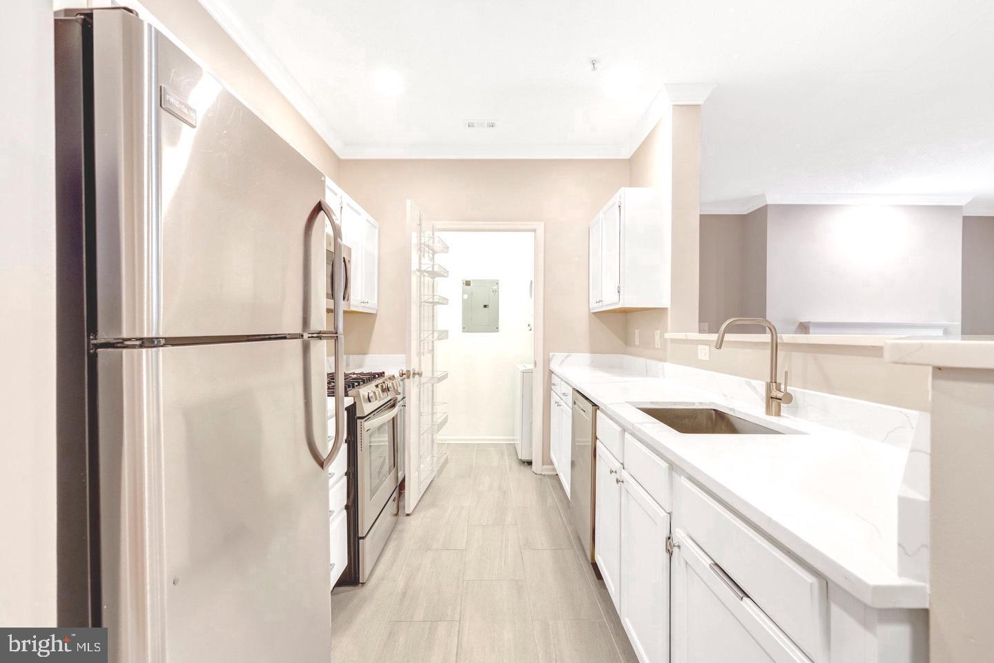 1701 Lake Shore Crest Drive, Unit 11 Reston, VA 20190 - Photo 5 of 33 a kitchen with a sink a refrigerator a washer and dryer