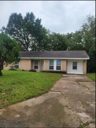 a front view of a house with a yard and trees