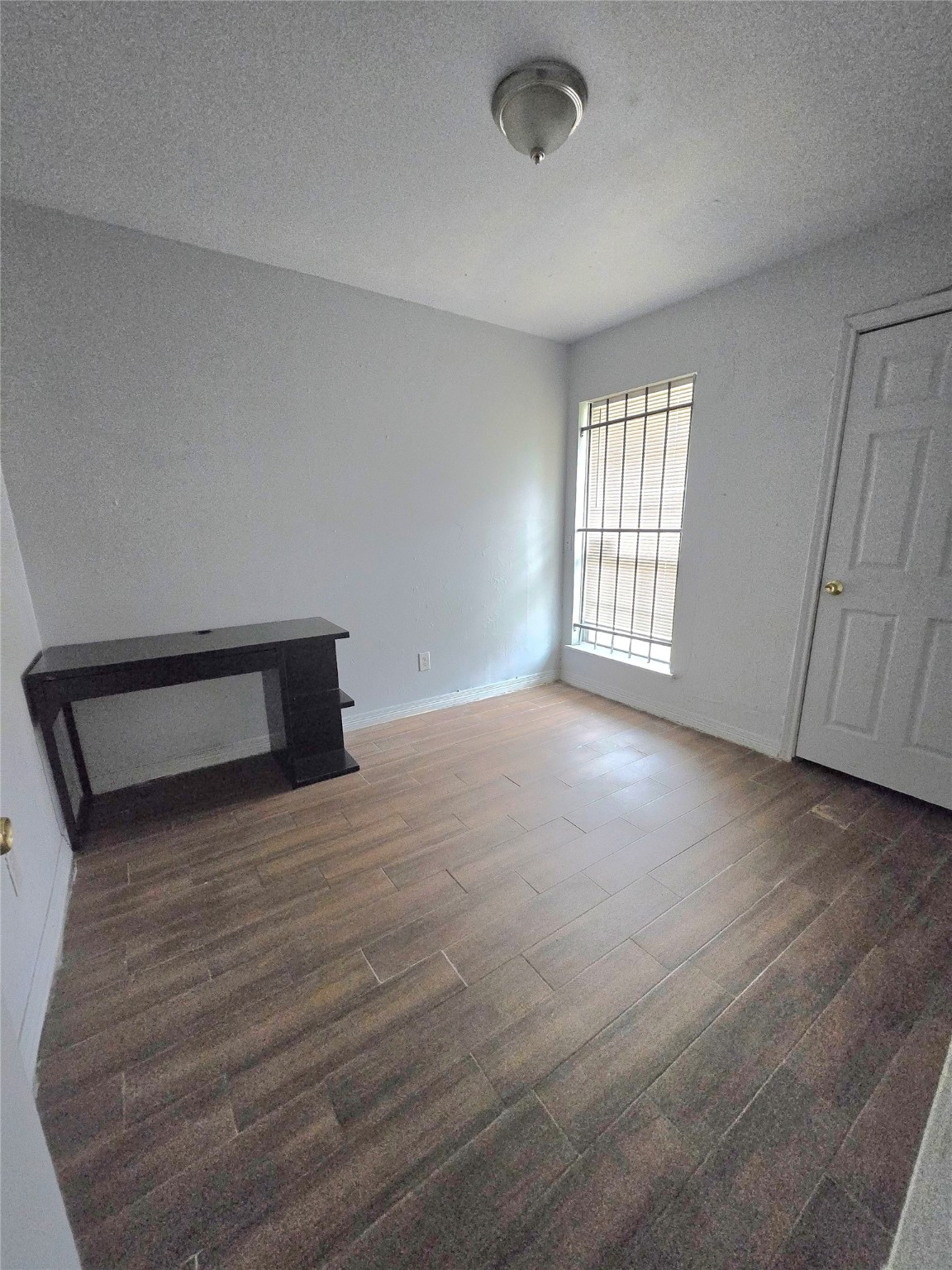 5530 Elm Spring Drive Houston, TX 77048 - Photo 12 of 15 a view of an empty room with wooden floor and a window