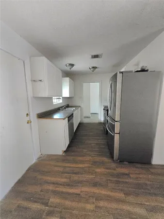 a view of a kitchen with a sink and refrigerator