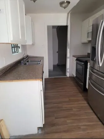 a kitchen with a refrigerator and a sink