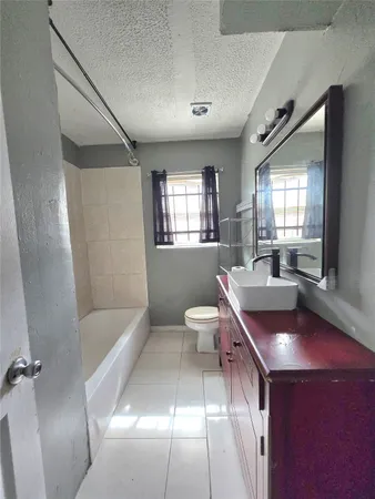 a bathroom with a tub sink and mirror