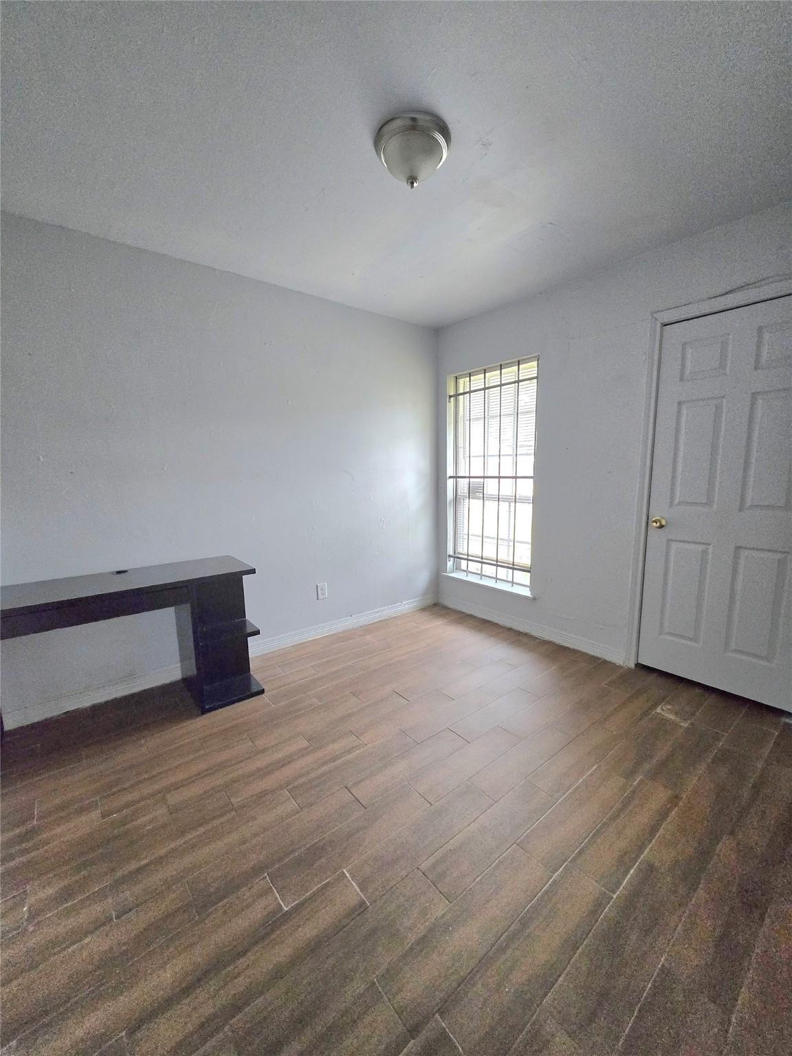 5530 Elm Spring Drive Houston, TX 77048 - Photo 10 of 15 a view of an empty room with wooden floor and a window