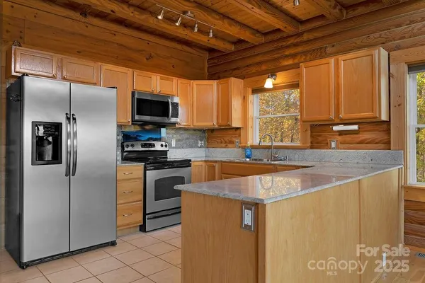 a kitchen with stainless steel appliances granite countertop a refrigerator and a sink