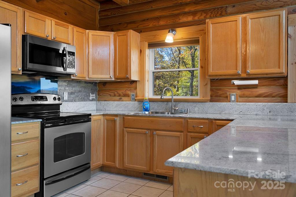85 Ridge Road Rosman, NC 28772 - Photo 14 of 48 a kitchen with stainless steel appliances granite countertop a sink a stove and a microwave