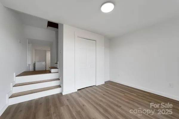 an empty room with wooden floor and sliding door