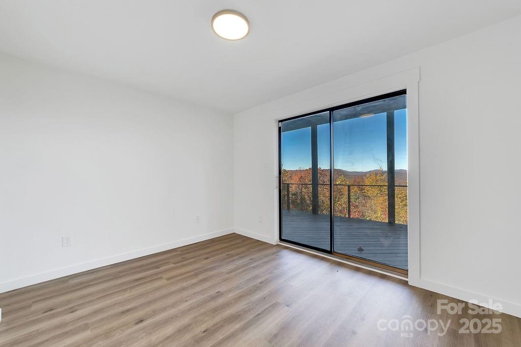 85 Ridge Road Rosman, NC 28772 - Photo 32 of 48 an empty room with wooden floor and sliding door