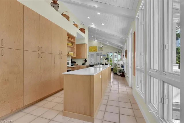 a view of a kitchen with kitchen island granite countertop lots of counter top space and living room view