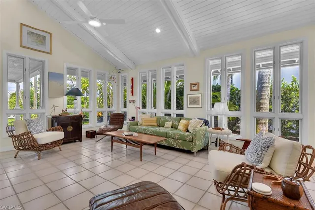 a living room with furniture and floor to ceiling windows