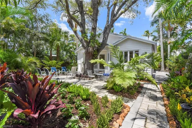 a front view of a house with a yard and potted plants