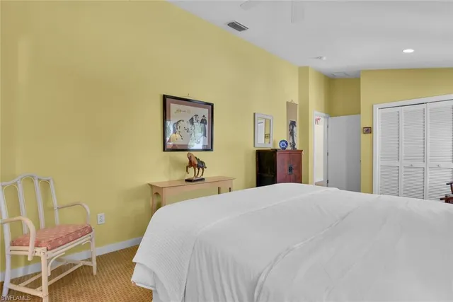 a spacious bedroom with a bed and a chair