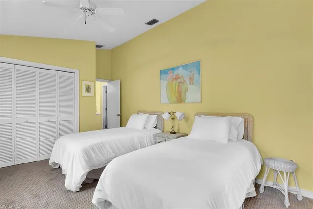 a bedroom with two beds and painting on the wall