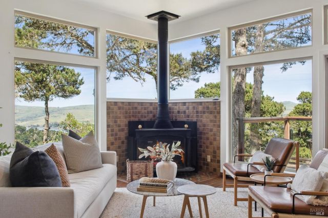 a living room with furniture fireplace and a large window