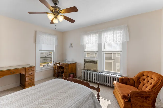 a bedroom with a bed wooden floor and window