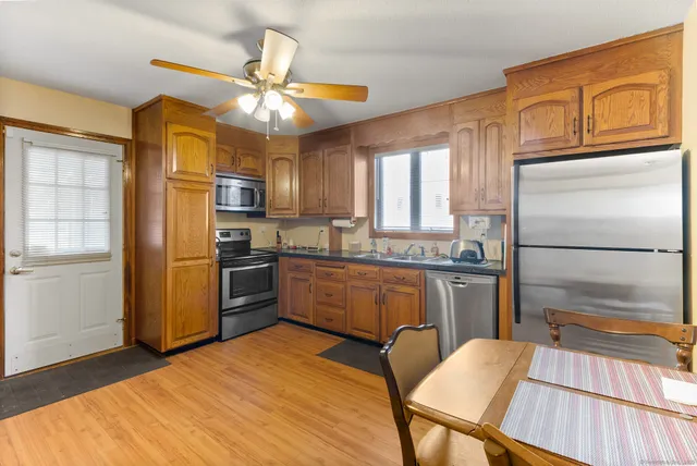 a kitchen with granite countertop a refrigerator stove top oven and sink