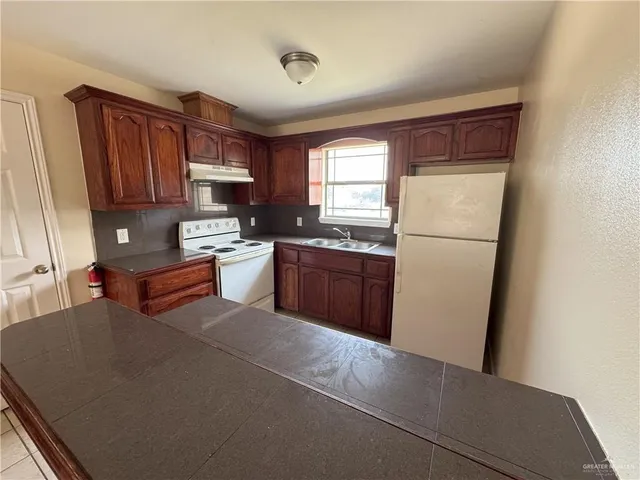 a kitchen with stainless steel appliances granite countertop a refrigerator sink and cabinets