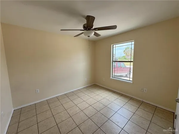 an empty room with windows and fan