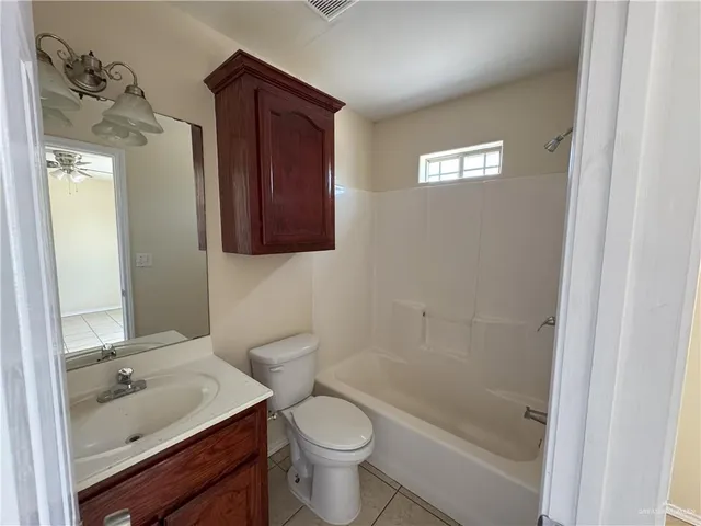 a bathroom with a granite countertop toilet a sink and a mirror