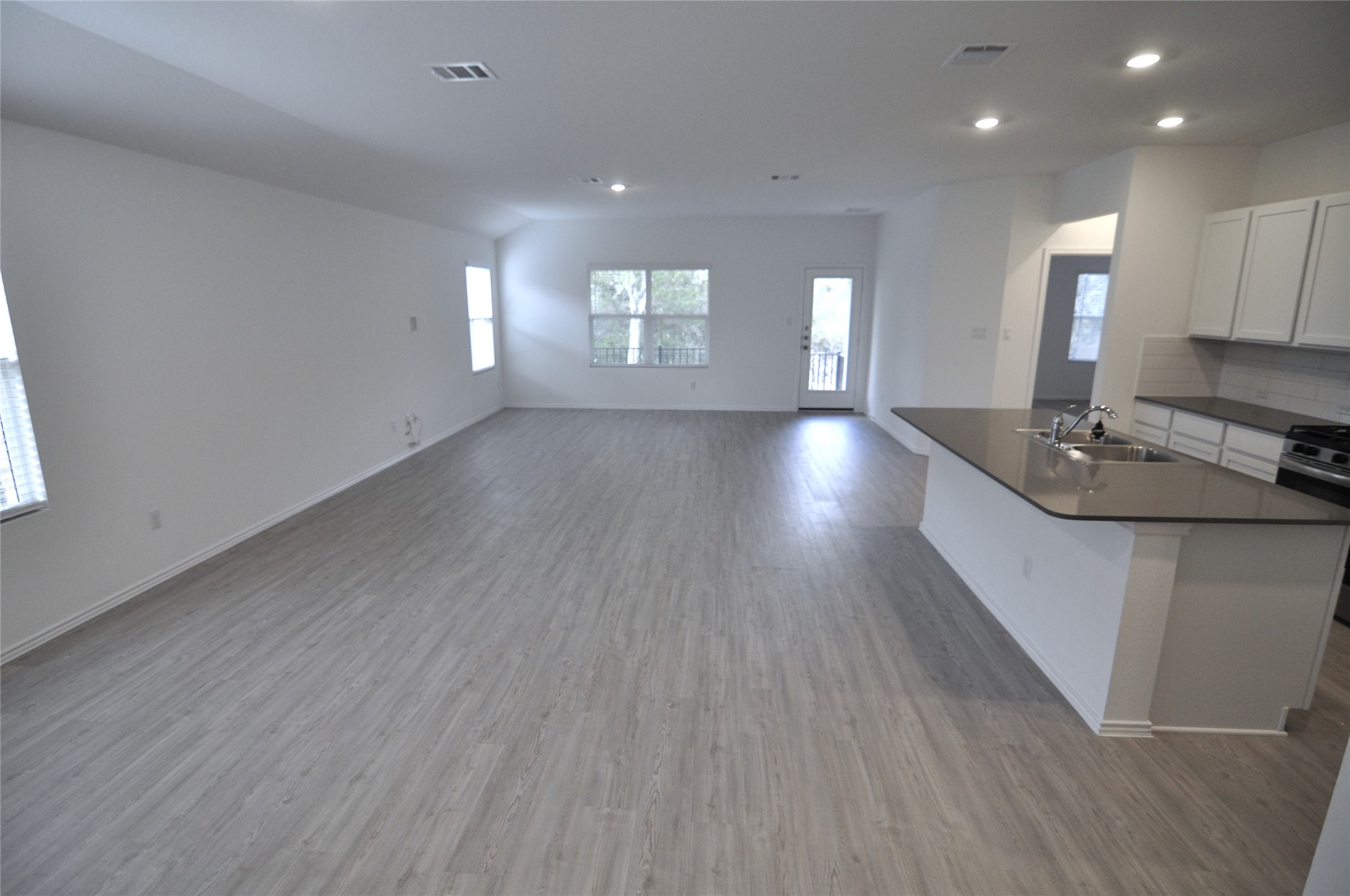 1537 Chapel Ranch Road Georgetown, TX 78628 - Photo 23 of 25 Kitchen featuring open floor plan, white cabinetry, a center island with sink, recessed lighting, and light wood-style floors