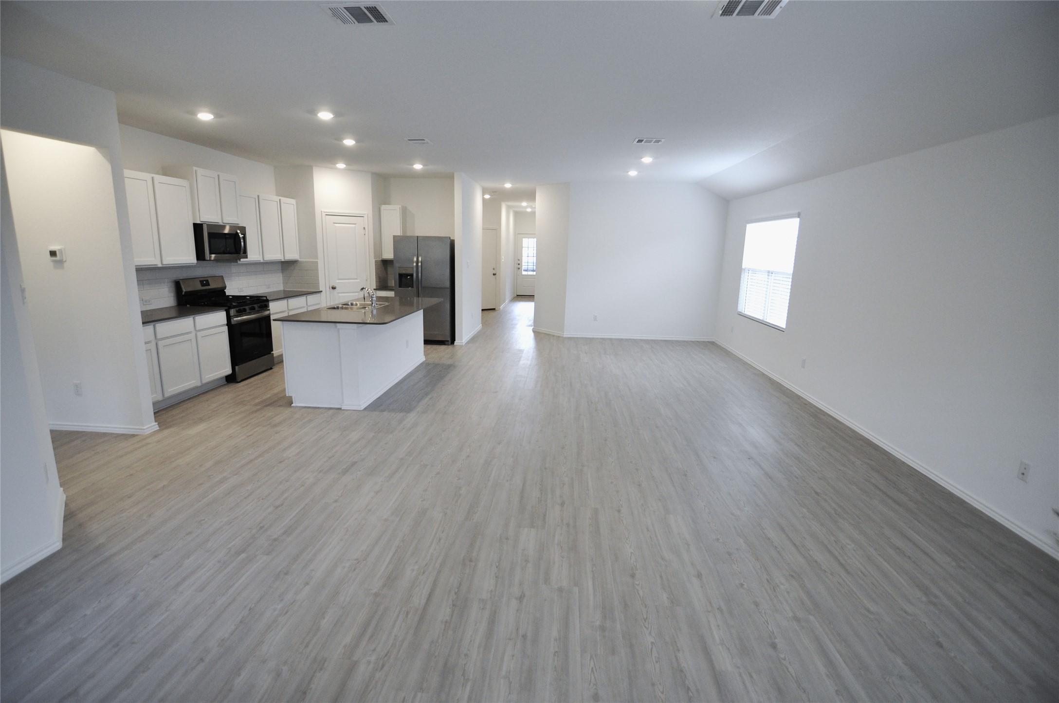 1537 Chapel Ranch Road Georgetown, TX 78628 - Photo 25 of 25 Kitchen with open floor plan, dark countertops, stainless steel appliances, white cabinetry, and an island with sink