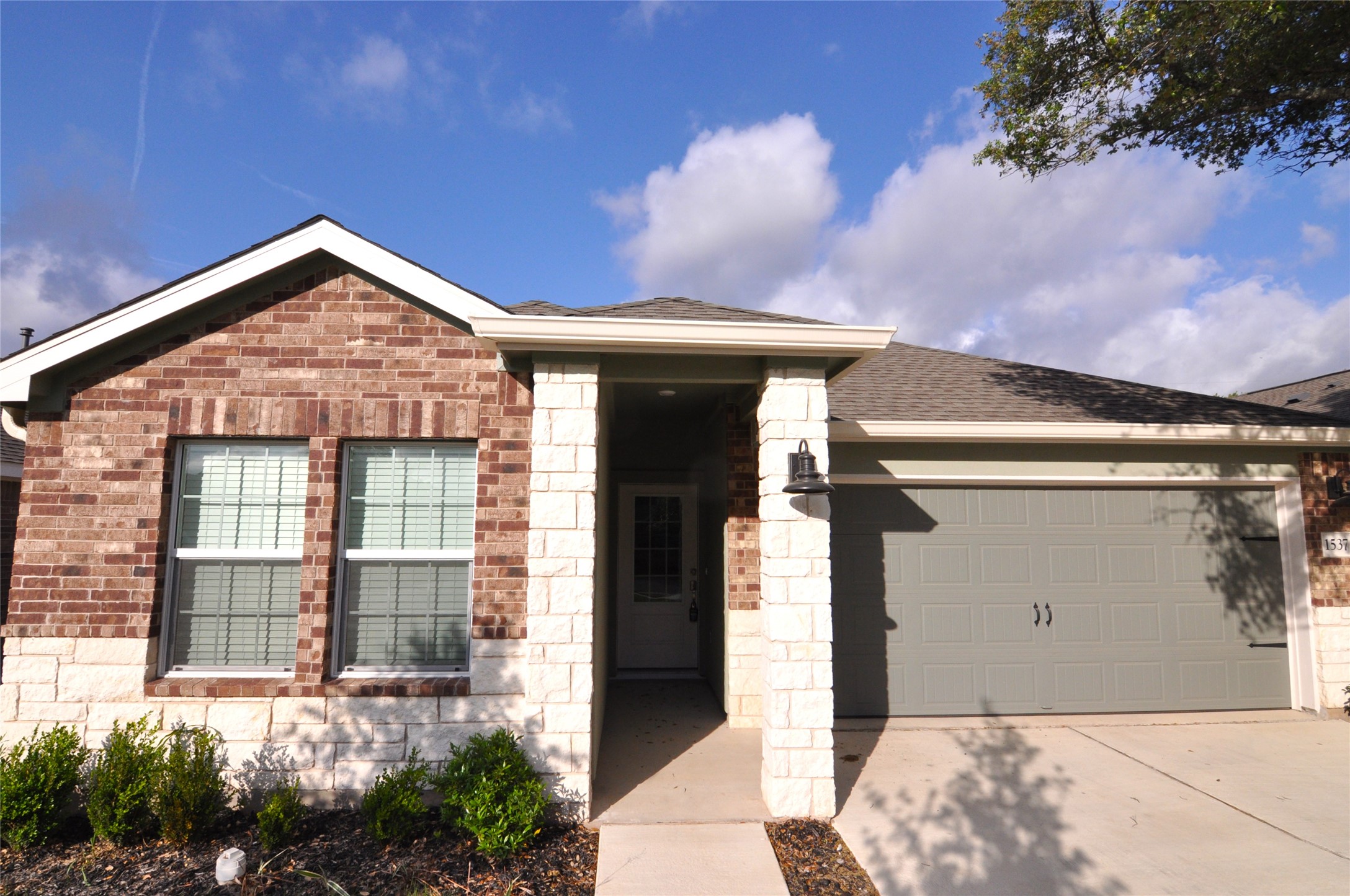 1537 Chapel Ranch Road Georgetown, TX 78628 - Photo 4 of 25 Ranch-style house featuring a garage, concrete driveway, brick siding, and a shingled roof