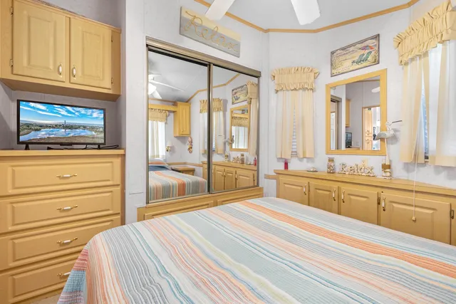 a bedroom with a bed and a large window with balcony view