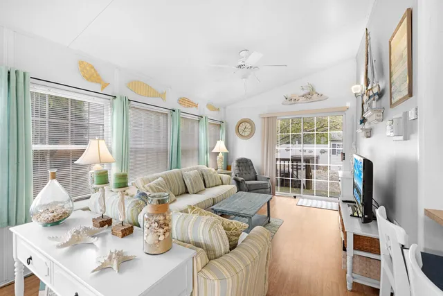 a living room with furniture a flat screen tv and a large window