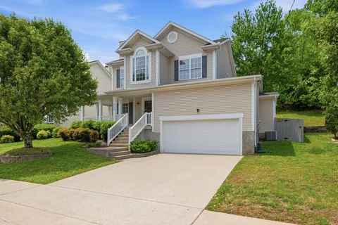 a front view of a house with a yard and trees