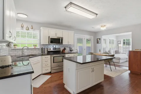 a kitchen with sink stove and cabinets