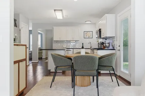 a dining room with furniture and a kitchen view