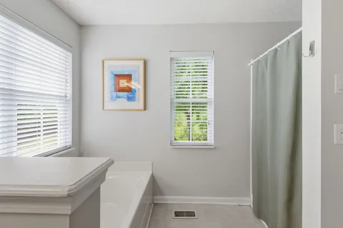 a bathroom with a bathtub a sink and a window
