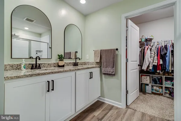 a bathroom with double vanity sink and a mirror
