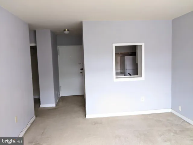 an empty room with closet and a window