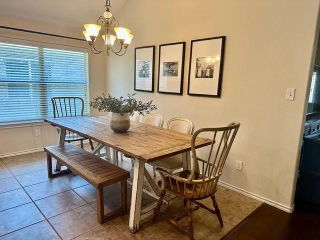 a view of a dining room with furniture a chandelier and wooden floor