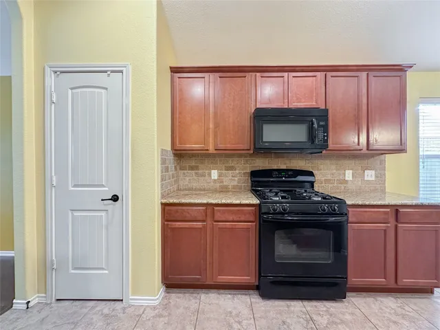 a kitchen with stainless steel appliances granite countertop a sink and a refrigerator