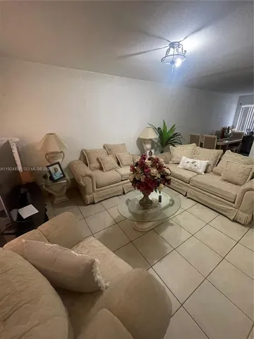a living room with furniture flowerpot and wooden floor