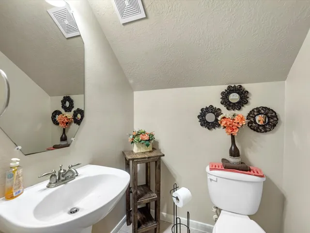 a bathroom with a sink mirror and toilet