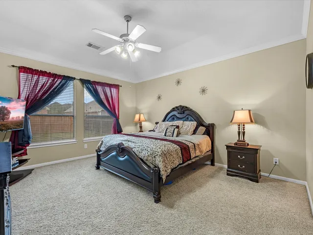 a spacious bedroom with a bed and a ceiling fan