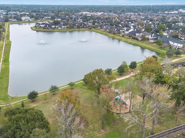 an aerial view of residential houses with outdoor space and lake view