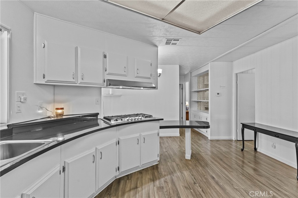 4000 Pierce Street, Unit 132 Riverside, CA 92505 - Photo 16 of 43 a kitchen with granite countertop a sink cabinets and wooden floor