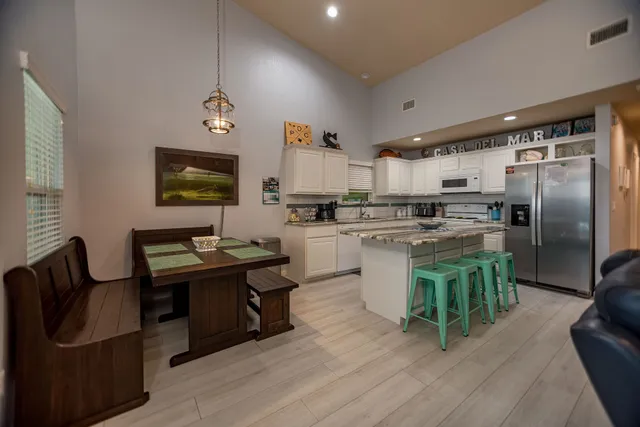 a living room with stainless steel appliances kitchen island granite countertop furniture a kitchen view and a refrigerator